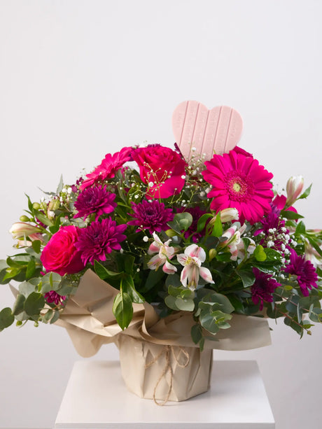 Pink mixed flower posy with gerbera, roses and chrysanthemums with heart-shaped chocolate 