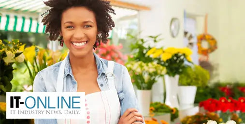 Woman in a floral shop with flowers and a 'IT-Online' logo.