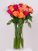 Hot pink and orange rose bouquet with gypsophila in glass vase