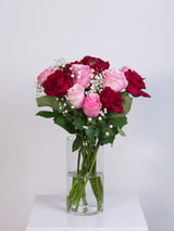 Pink and red rose bouquet with gypsophila in a glass vase