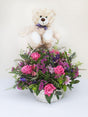 Bear basket with pink and blue flowers celebrating a newborn's arrival, featuring seasonal blooms in a charming white basket.
