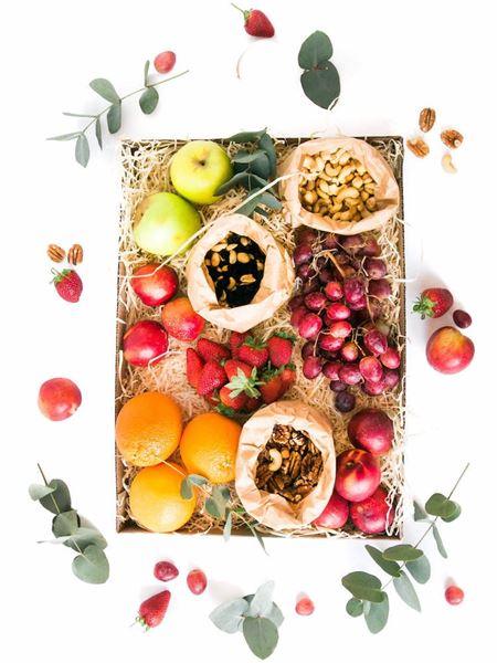 Nut and fruit snack box with oranges, apples, grapes, strawberries, and mixed nuts for a healthy, energizing treat.