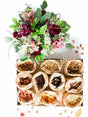Luxury jumbo snack box with dried fruits, nuts, and vibrant floral arrangement in red, white, and pink, perfect gift idea.