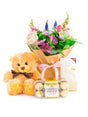 Newborn girl gift set with pink floral bouquet, teddy bear, luxury Lindt chocolate slab, and Ferrero Rocher chocolates.