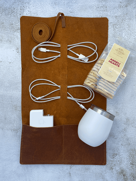 Stylish leather cable holder with cords, Lizzard Thermo cup, and Angeli Heart cookies for organized and delightful gifting.