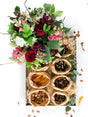 Savoury jumbo snack box with biltong, dried meats, nuts, dried fruits, and a floral arrangement in a clear glass vase.