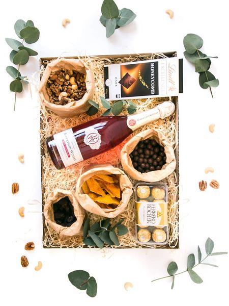 Gift box with non-alcoholic pink champagne, Lindt chocolate, mixed nuts, Ferrero Rocher, dried fruit, and Maltesers.