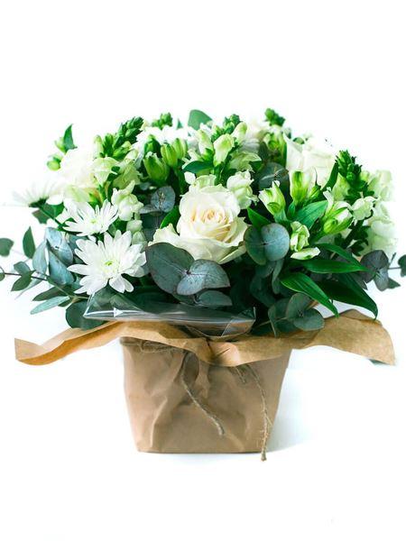 Elegant white posy with roses, snapdragons, alstroemeria, chrysanthemums, and greenery in paper wrap.