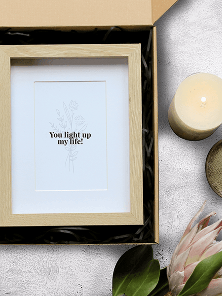 "You Light Up My Life" gift set with photo frame and scented candle in a natural kraft box, promoting empowerment through pottery.